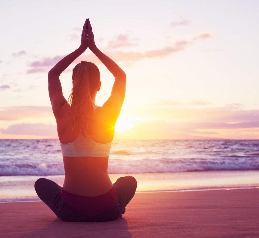 woman doing yoga on the beach